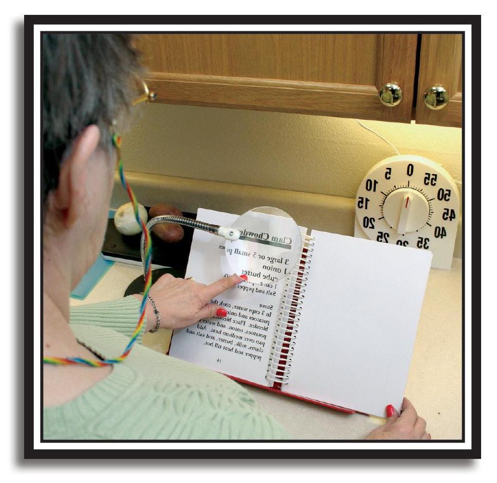 照片中的女人在厨房里用放大镜阅读食谱